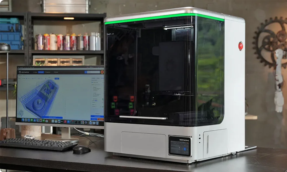 NestWorks C500 enclosed desktop CNC machine beside a computer showing CAM software
